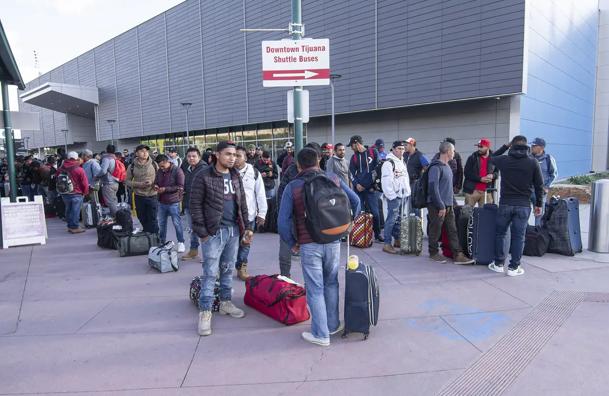 Migrant workers from Mexico wait for buses to transport them to seasonal work destinations